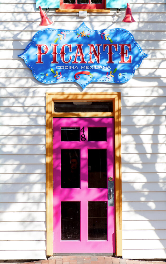 A pink door and window on the outside of a building.