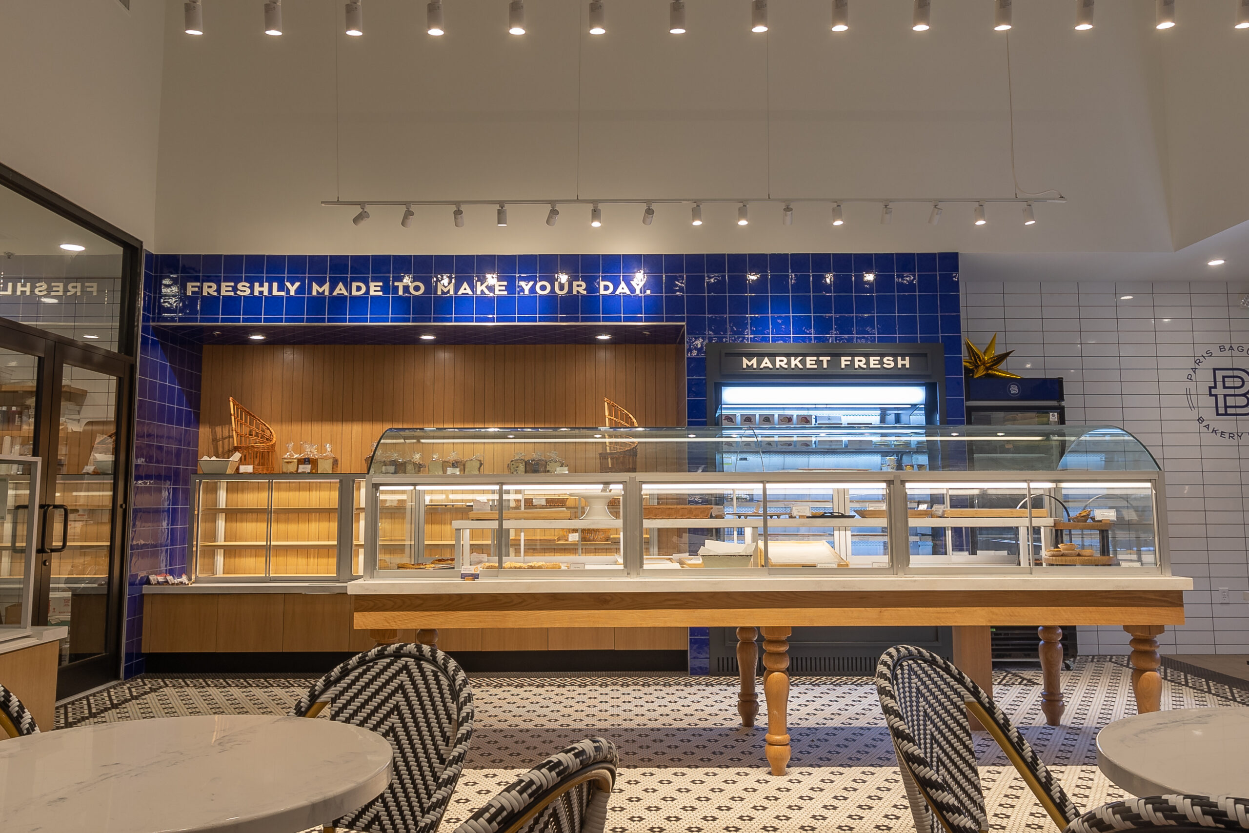 A restaurant with tables and chairs in front of the counter.