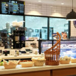 Bakery counter with pastries and coffee machines.