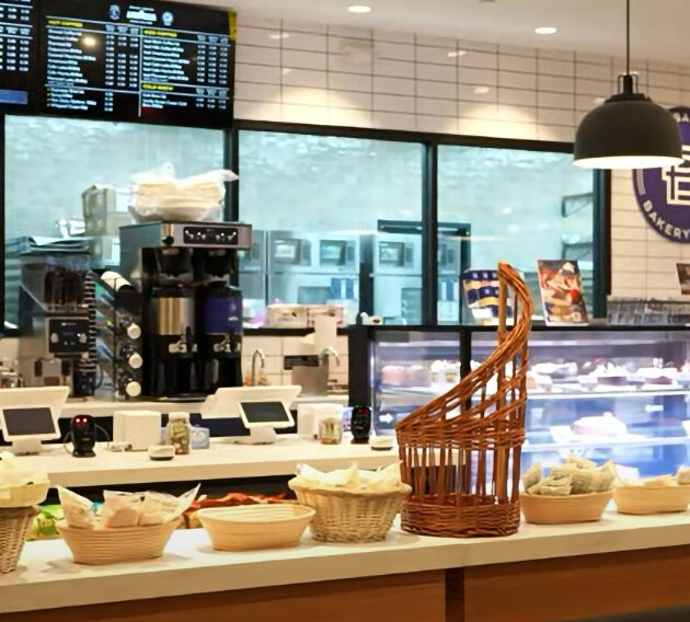 Bakery counter with pastries and coffee machines.