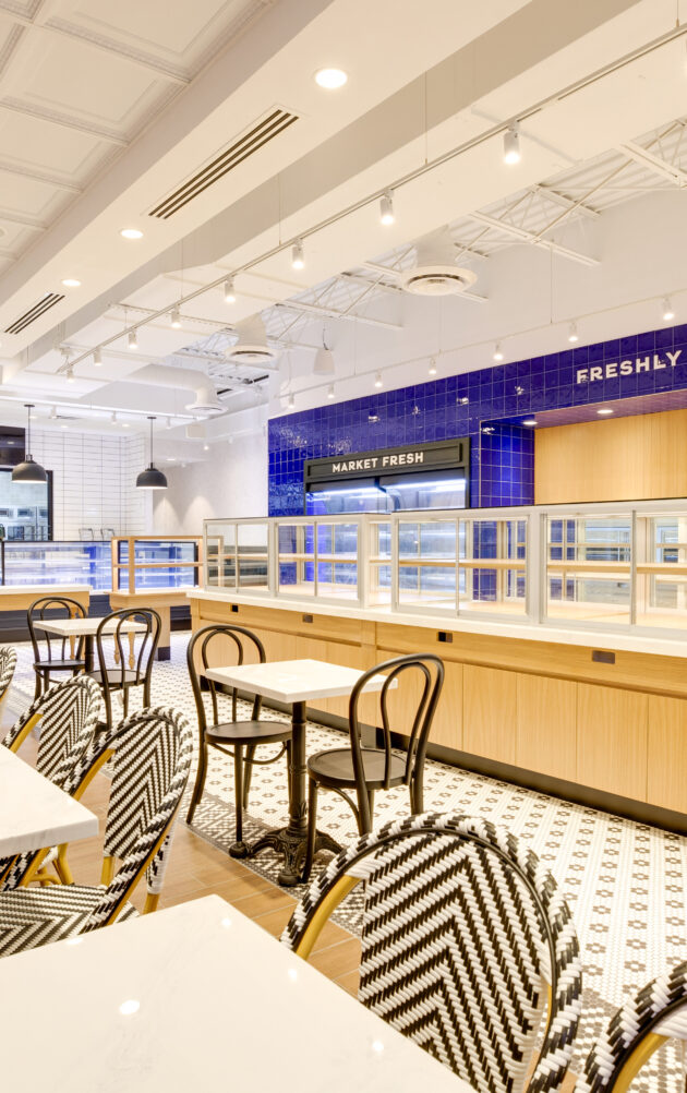 Modern caf interior with seating and display cases.