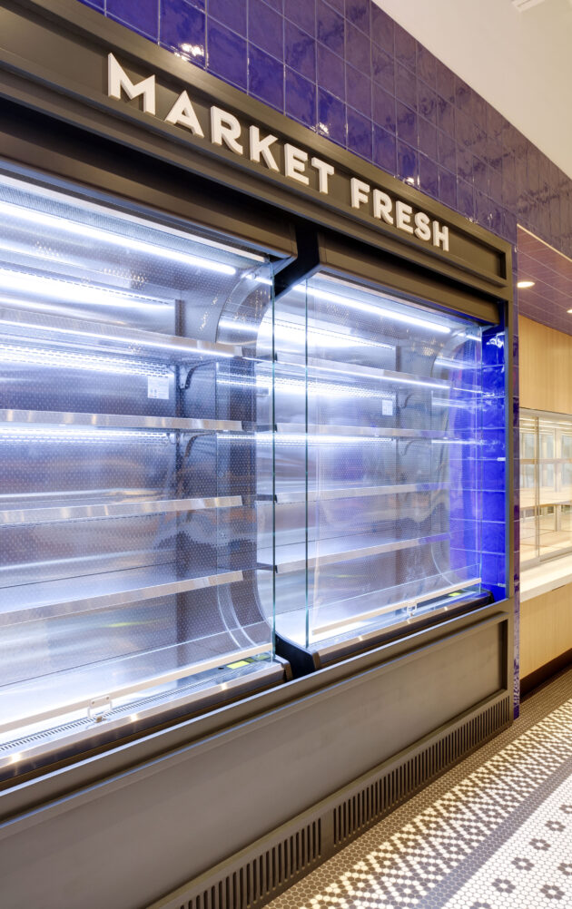 Empty refrigerated shelves in a grocery store.